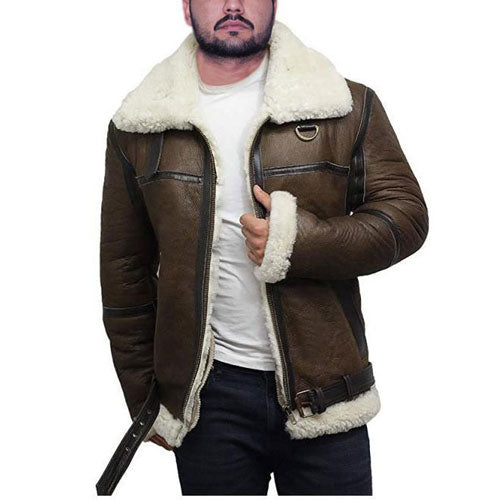 A man wearing a brown sheepskin leather jacket with a fur lining on the collar and cuffs, paired with a white shirt and blue jeans.
